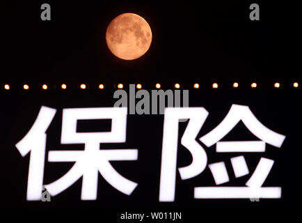 The start of a rare 'blue moon,' which is red due to the pollution in the atmosphere, rises over Beijing on August 30, 2012.  Called 'blue' due the rarity of it, the 'blue moon' occurs when there's a second full moon in one calendar month, with the next one not happening until July 2015.  U.S. astronaut Neil Armstrong's family has suggested paying tribute to the first man on the moon by looking up at the moon and giving the astronaut a wink.    UPI/Stephen Shaver Stock Photo