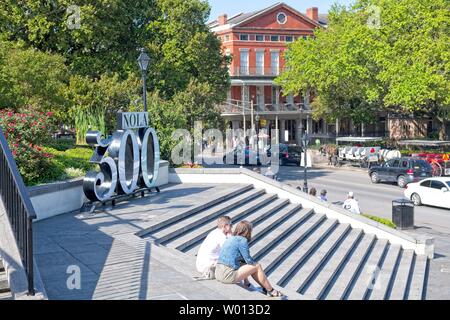 A couple sits on the steps of a park in New Orleans, Louisiana Stock Photo