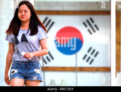 A Chinese woman walks past a travel agency specializing in trips and packages to South Korea in downtown Beijing on August 27, 2013.   South Korea remains one of the top tourist destinations for Chinese, despite recurrent tensions between the two countries.      UPI/Stephen Shaver Stock Photo