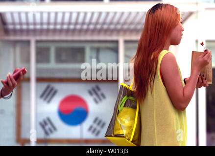 A Chinese woman walks past a travel agency specializing in trips and packages to South Korea in downtown Beijing on August 27, 2013.   South Korea remains one of the top tourist destinations for Chinese, despite recurrent tensions between the two countries.    UPI/Stephen Shaver Stock Photo