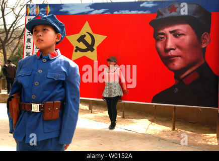 A Chinese boy dressed in a communist uniform poses for a photo, in front of a banner of the communist party's ideal soldier Li Feng, at a site used by former helmsman Mao Zedong and other leaders to discuss policy and future strategies in the Yangjialing Revolution, in Yan'an, Shaanxi Province, on April 6, 2014.  Yan'an was close to the endpoint of the Long March, and became the center of the Chinese Communist revolution led my Mao from the 1936 to 1948.  Chinese communists celebrate the city as the birthplace of modern China and the cult of Mao.     UPI/Stephen Shaver
