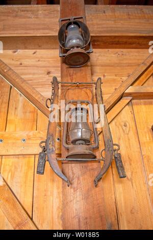 A rusty antique lantern hangs from a farmhouse wall Stock Photo