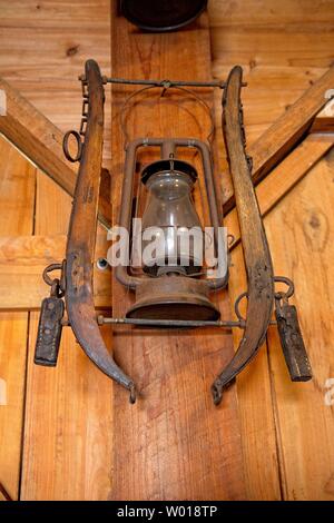 A rusty antique lantern hangs from a farmhouse wall Stock Photo