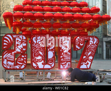 Chinese workers set-up a Chinese New Year's display of red lanterns prior ahead the start of its New Year  in Beijing on January 22, 2017. This year's Chinese New Year - The Year of the Rooster - begins January 28 and lasts about two weeks.   Also known as the Spring Festival, it is one of China's most important  holidays which sees millions of Chinese traveling home with gifts  for their families.    Photo by Stephen Shaver/UPI Stock Photo