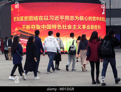 Chinese walk past a giant electronic monitor displaying slogans promoting President Xi Jinping and the Communist Party at an office complex in downtown Beijing on October 29, 2017.  China's Communist Party elevated Xi to the same status as the nation's founding father, Mao Zedong, by writing his name and ideas into the party constitution.      Photo by Stephen Shaver/UPI Stock Photo