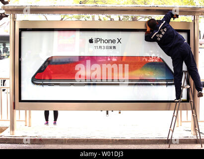 A Chinese worker cleans a street advertisement for the new Apple iPhone X to be released on November 3 in Beijing on October 29, 2017.  Preorders for Apple's iPhone X sold out in 10 minutes online to people in more than 50 countries.   Photo by Stephen Shaver/UPI Stock Photo