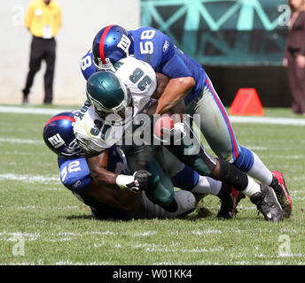 New York's linebacker Antonio Pierce (#58) and defensive end Michael Strahan (#92) get Philadelphia's Brian Westbrook (#36) between them as they bring him  down for no gain during second quarter Philadelphia Eagles-New York Giants NFL football action at Philadelphia's Lincoln Field September 17, 2006. New York defeated Philadelphia in overtime 24-30.     (UPI Photo/John Anderson) Stock Photo