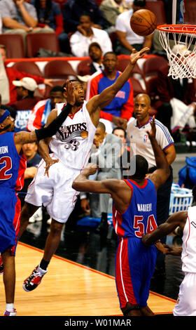 Philadelphia 76ers Willie Green (33) sails through the air to score two points as Detroit Pistons Jason Maxiell (54) looks on during fourth quarter playoff action at the Wachovia Center in Philadelphia April 27, 2008. Detroit defeated Philadelphia 93-84 to even the series at 2 each. Player at far left is Detroit Richard Hamilton.    (UPI Photo/John Anderson) Stock Photo