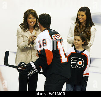 Republican Vice-Presidential candidate Alaska Gov. Sarah Palin expresses her gratitude as Philadelphia Flyers team captain Mike Richards presents her with the ceremonial first puck of the season in Philadelphia at the Wachovia Center on October 11, 2008. Looking on are two of Palin's children, Piper and Willow. Palin dropped the puck at the home opening game. (UPI Photo/John Anderson) Stock Photo