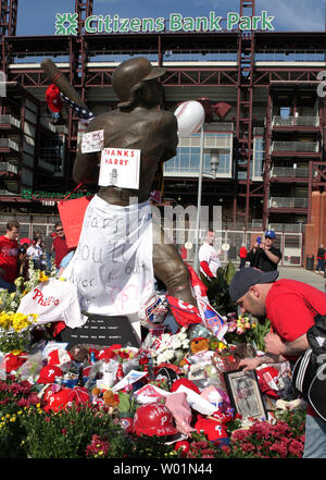 Flowers, notes of remembrance and jerseys are left at the base of a statue  of Philadelphia baseball player Mike Schmidt that has been tuned into a  memorial for longtime Philadelphia Phillies announcer