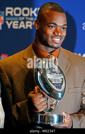 Minnesota Vikings running back Adrian Peterson holds his trophy for being  named the NFL's 2007 rookie of the year during a press conference at the  NFL's Super Bowl XLII media center in