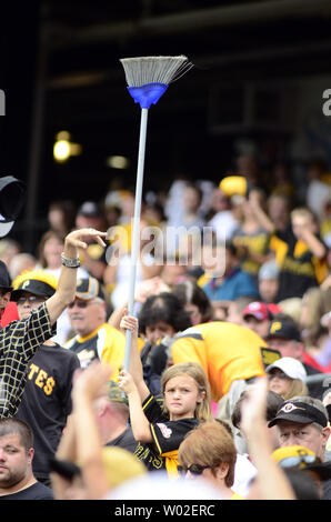 A Pittsburgh Pirates fans waves a Jolly Roger flag and holds a broom to  celebrate the Pirates' sweeping of a four-game series against the  Cincinnati Reds in a baseball game in Pittsburgh