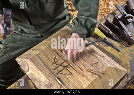 wood chisel carpenter tool hammer in hand working wooden background Stock Photo