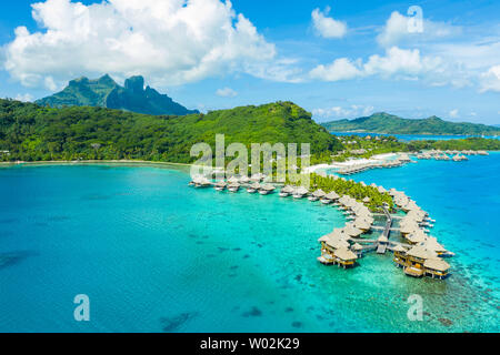 Travel vacation paradise aerial drone video with overwater bungalows luxury resort in coral reef lagoon ocean beach. Aerial of Mount Otemanu, Bora Bora, French Polynesia, Tahiti, South Pacific Ocean Stock Photo