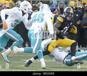 Miami Dolphins free safety Bacarri Rambo (30) brings down Pittsburgh  Steelers running back Le'Veon Bell (26) as Miami Dolphins outside  linebacker Neville Hewitt (46) and Miami Dolphins cornerback Ifo  Ekpre-Olomu (33) closes