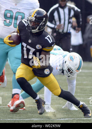 Miami Dolphins free safety Bacarri Rambo (30) brings down Pittsburgh  Steelers running back Le'Veon Bell (26) as Miami Dolphins outside  linebacker Neville Hewitt (46) and Miami Dolphins cornerback Ifo  Ekpre-Olomu (33) closes