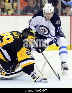 Winnipeg Jets' Adam Lowry (17) fights with New York Islanders' Anders ...