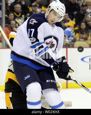 Winnipeg Jets' Adam Lowry (17) fights with New York Islanders' Anders ...