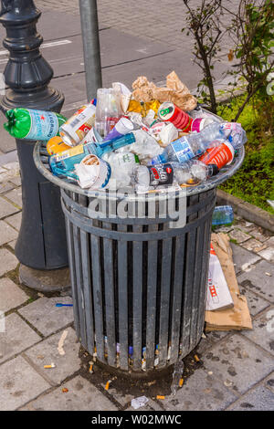 Public waste basket overflowing with discarded soft drinks bottles and cans - Brussels, Belgium. Stock Photo