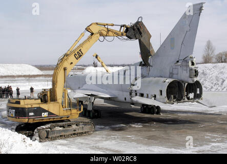 An excavator cuts the last strategic Tupolev Tu-22M3 Backfire bomber at an airbase outside of Ukrainian town Poltava, 200 miles southeast of Kiev, January 27, 2006. Ukraine inherited from the Soviet Union 60 Tu-22 bombers and 423 X-22 cruise missiles and eliminate them according to the 1993 agreement with US on the elimination of strategic nuclear weapons and nuclear non-proliferation. (UPI Photo/Sergey Starostenko) Stock Photo