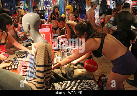 Women look through the clothing collection during Desigual's Semi-Naked  Party event in Paris on January 9, 2013. The event, marking the start of  the Paris winter sale season, offers the first 100