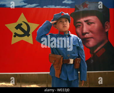A Chinese boy dressed in a communist uniform poses for a photo, in front of a banner of the communist party's ideal soldier Li Feng, at a site used by former helmsman Mao Zedong and other leaders to discuss policy and future strategies in the Yangjialing Revolution, in Yan'an, Shaanxi Province, on April 6, 2014.  Yan'an was close to the endpoint of the Long March, and became the center of the Chinese Communist revolution led my Mao from the 1936 to 1948.  Chinese communists celebrate the city as the birthplace of modern China and the cult of Mao.     UPI/Stephen Shaver
