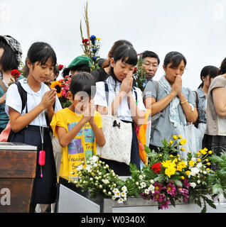 People pray for the atomic bomb victims at Hiroshima Peace Memorial Park marking the 69th anniversary of the atomic bombing in Hiroshima, Japan, on August 6, 2014.   An American B-29 dropped an atomic bomb on Hiroshima killing tens of thousands and hastening the end of World War II.  UPI/Keizo Mori Stock Photo