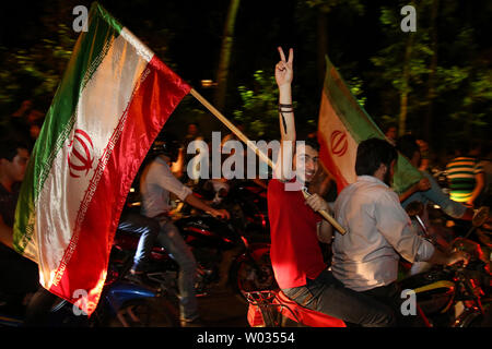 Iranians celebrate on the streets of Tehran after the announcement of