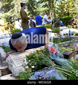 An Israeli kisses the grave of a family member on Israel's  Memorial Day for fallen soldiers and terror victims in the Mount Herzl Military Cemetery in Jerusalem, Israel May 11, 2016. Israel is marking Memorial Day to commemorate 23,477 fallen soldiers and 2,517 civilians killed in terror  attacks hours before the country's mourning turns to festivities when Israel's 68th Independence Day begins Wednesday night. Photo by Debbie Hill/UPI Stock Photo