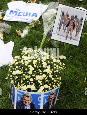 One the site where the statue of  former Penn State coach Joe Paterno stood,  fans leave flowers, a tee-shirt and photos of the late  coach following the 24-14 Penn State loss to Ohio University at Beaver Stadium in University Park, Pennsylvania on September 1, 2012.    UPI/Archie Carpenter Stock Photo