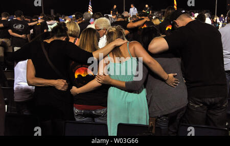 People pray at a memorial service for the nineteen Granite Mountain Hotshots, killed Sunday fighting the Yarnell Hill Fire, in Prescott, Arizona on July 2, 2013.   UPI/Art Foxall Stock Photo