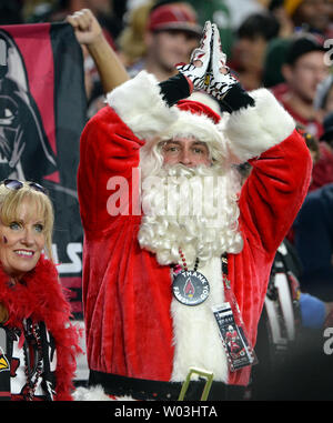 An Arizona Cardinals fan, dressed as Santa Claus, cheers during the first  half of an NFL football game against the Indianapolis Colts, Saturday, Dec.  25, 2021, in Glendale, Ariz. (AP Photo/Rick Scuteri