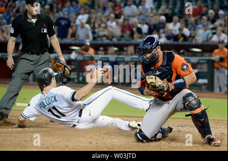 Arizona Diamondbacks' A. J. Pollock (C) slides in to home safely as Houston Astros' catcher Max Stassi fields the wide throw in the fourth inning at Chase Field in Phoenix, Arizona, August 15, 2017. Watching the play is home plate umpire Chris Guccione. The Astros defeated the Diamondbacks 9-4.     Photo by Art Foxall/UPI Stock Photo