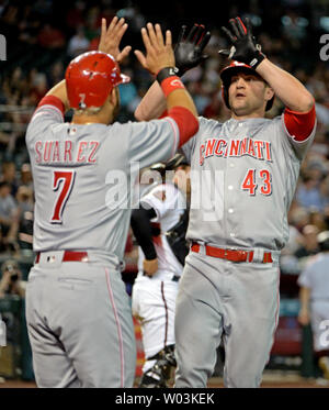 Cincinnati Reds' Eugenio Suarez (7) celebrates with third base coach ...