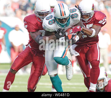 Miami Dolphins Wide Receiver Marty Booker (86) is tackled by Arizona Cardinals Adrian Wilson (24) and David Macklin (27) during second half action on November 7, 2004 at Pro Player Stadium in Miami, Fl. The Arizona Cardinals beat the Miami Dolphins 24-23. (UPI Photo/Robert Stolpe) Stock Photo
