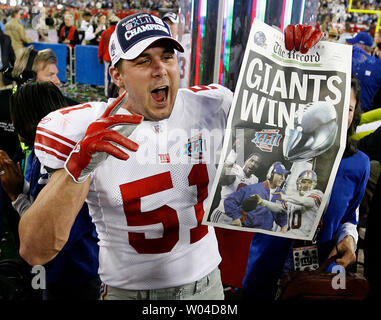 New York Giants line backer Zak DeOssie holds up a newspaper proclaiming  the Giants' win over the New England Patriots at Super Bowl XLII at  University of Phoenix Stadium in Glendale, Arizona