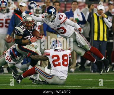 The New York Giants' Gibril Wilson holds on to Dallas Cowboys running back  Julius Jones (21), as teammate Osi Umenyiora comes in to help out in the  first quarter. The Cowboys defeated