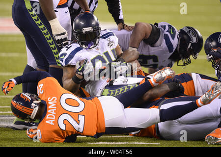 Seattle Seahawks running back Marshawn Lynch (24) looks over at Denver  Broncos free safety Mike Adams (20) after being tackled on his run during  the second quarter at the Super Bowl XLVIII at MetLife Stadium in East  Rutherford, New Jersey on