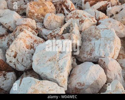 Large marble boulders of sea embankment in the evening light. Stock Photo
