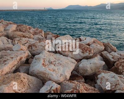Large marble boulders of sea embankment in the evening light. Stock Photo