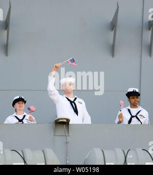 Sailors wave American flags from the deck of the USS Ronald Reagan aircraft carrier as it docked at Naval Air Station North Island in Coronado, California, July 6, 2006. The nuclear-powered aircraft carrier and its crew of nearly 5,000 sailors returned to San Diego from a six-month deployment to the Persian Gulf and Western Pacific Ocean. It was the first mission for the ship since being commissioned in 2003. (UPI Photo / Earl S.Cryer) Stock Photo