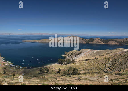 Boats in the bay and agricultural terracing on Isla del Sol, Lake Titicaca, Bolivia Stock Photo