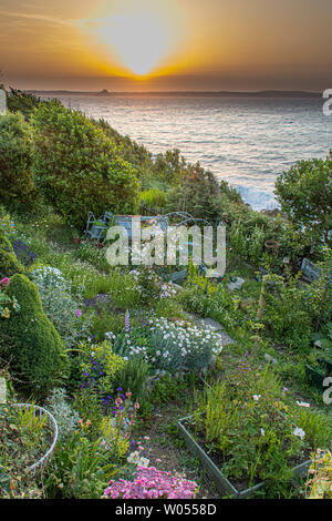 Mousehole, Cornwall, UK. 27th June 2019. UK Weather. Sunrise this morning as viewed from this cliffside allotment at Mousehole. Credit Simon Maycock / Alamy Live News. Stock Photo