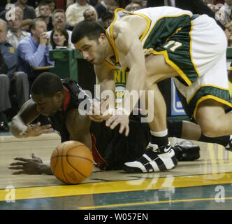 Miami Heat's Dwyane Wade, left, and Seattle Supersonics' Vladimir Radmanovic of Serbia & Montenegro, right, go for a loose ball in the second quarter at Key Arena in Seattle on January 13, 2006. (UPI Photo/Jim Bryant). Stock Photo