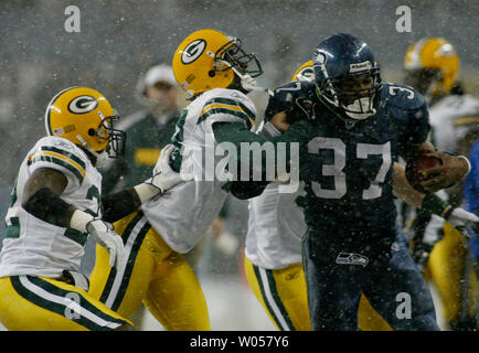 Seattle Seahawks running back Shaun Alexander, right, runs through the tackle of Green Bay Packers' free safety Nick Collins, center, for a first down during the first quarter November 27, 2006 in Seattle. Backing up Collins is strong safety Marquand Manuel, left. (UPI Photo/Jim Bryant) Stock Photo