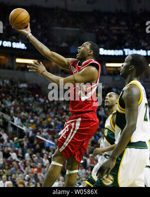 Houston Rockets' Tracy McGrady goes to the basket past Seattle Supersonics' Johan Petro, of France (R) and Rashard Lewis during the first half at the Key Arena in Seattle on April 9, 2007. (UPI Photo/Jim Bryant) Stock Photo