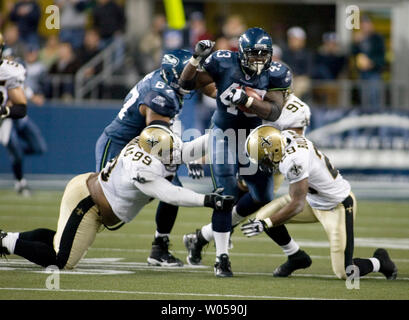 Seattle Seahawks'  fullback Leonard Weaver (C) is tackled by New Orleans Saints'  Hollis Thomas (99), Josh Bullocks (29) and WIll Smith (91) in the fourth quarter at Qwest Field in Seattle on October 14, 2007. (UPI Photo/Jim Bryant). Stock Photo
