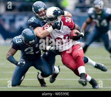 Arizona Cardinals' running back Edgerrin James (R) is tackled by Seattle  Seahawks' cornerback Marcus Truffant (R) and free safety Brian Russell (C)  in the second half at Qwest Field in Seattle on