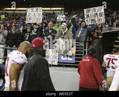 Seattle Seahawks quarterback Russell Wilson scrambles against San Francisco  49ers linebacker Patrick Willis and defensive tackle Ray McDonald at  CenturyLink Field in Seattle, Washington on December 23, 2012. Wilson  completed 15 of