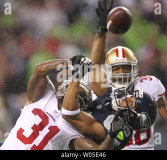 Seattle Seahawks quarterback Russell Wilson scrambles against San Francisco  49ers linebacker Patrick Willis and defensive tackle Ray McDonald at  CenturyLink Field in Seattle, Washington on December 23, 2012. Wilson  completed 15 of